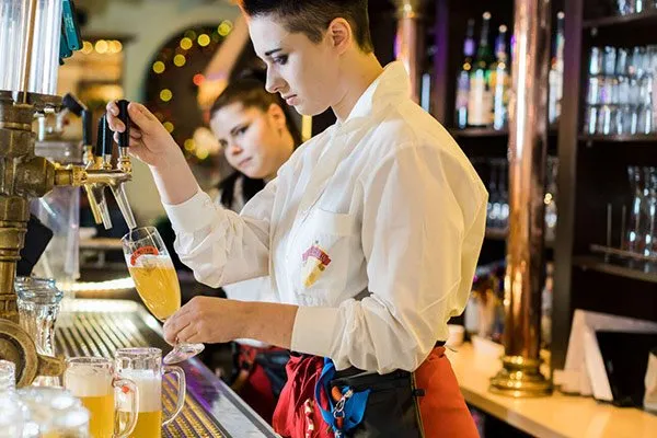 Mitarbeiterin zapft frisches Webster Bier am Tresen